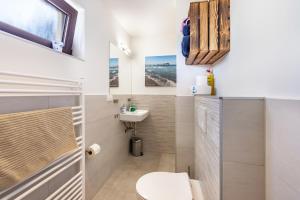a bathroom with a toilet and a sink at Ostseekind in Timmendorfer Strand +20 photos