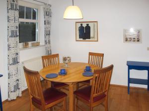 a dining room with a wooden table and chairs at Apartment Juliusruh-3 by Interhome in Juliusruh
