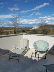 two chairs and a glass table on a roof at Gîte SPA Sauna Piscine in Grospierres
