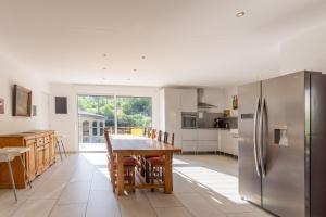 a kitchen with a table and a stainless steel refrigerator at Villa Luminières 2 in Sallelles