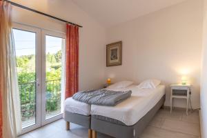 a bedroom with a bed and a large window at Villa Luminières 2 in Sallelles +22 photos