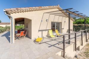 a patio with chairs and a metal structure at Villa Luminières 2 in Sallelles