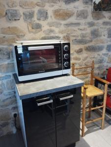 a microwave oven sitting on top of a counter at Gîte SPA Sauna Piscine in Grospierres