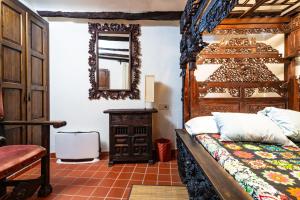a bedroom with a wooden bed and a mirror at Casa Retiro Vilafames in Vilafamés