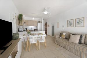 a kitchen and living room with a couch and a table at Serene Terrace And Pool in Playa de las Americas