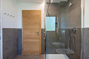 a bathroom with a shower and a glass door at Mongaduierhof Apt Latemar in Umes +25 photos
