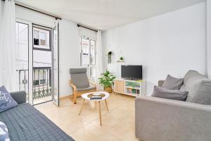 a living room with a couch and a tv at Apartamento B y G Nerja in Nerja