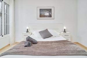 a white bedroom with a large bed and two lamps at Apartamento B y G Nerja in Nerja