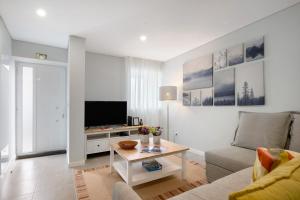 a living room with a couch and a tv at V L P Amorim in Ponta Delgada