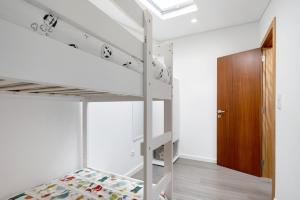 a bedroom with bunk beds and a door at V L P Amorim in Ponta Delgada