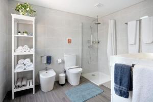 a bathroom with a toilet and a shower and a sink at V L P Amorim in Ponta Delgada