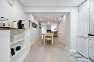 a kitchen with white walls and a dining room with a table at V L P Amorim in Ponta Delgada +18 photos