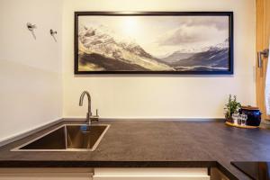 a kitchen with a sink and a painting on the wall at Ferienwohnung Kuppelwies 363 in Ultimo