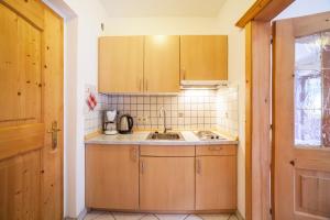 a kitchen with wooden cabinets and a sink at Sonnenparadies Apartement 2 in Saltusio +13 photos