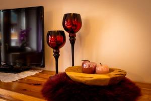 two wine glasses and a bowl of apples on a table at Sonnenparadies Apartement 2 in Saltusio
