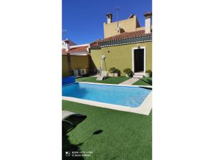 a swimming pool in a yard next to a house at Villa Pepa in Chilches