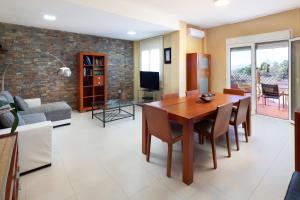 a dining room and living room with a table and chairs at Villa Pepa in Chilches