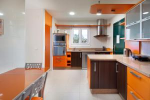 a large kitchen with brown cabinets and orange appliances at Villa Pepa in Chilches