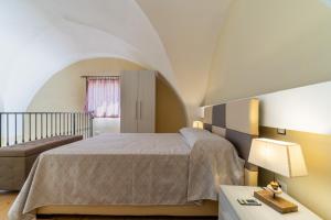 ein Schlafzimmer mit einem Bett und einem Tisch mit einer Lampe in der Unterkunft La rimesa di Tittì - Simone in Alezio