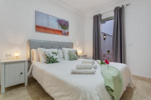 a bedroom with a white bed with towels on it at Apartamento Rolycar 101 in Icod de los Vinos