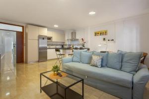 a living room with a blue couch and a kitchen at Apartamento Rolycar 101 in Icod de los Vinos