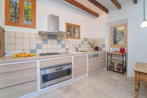 a kitchen with a sink and a stove top oven at Se Taulera in Fornalutx +16 photos