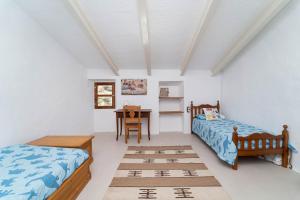 a bedroom with two beds and a table at Se Taulera in Fornalutx
