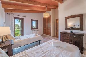 a bedroom with two beds and a dresser and a mirror at Es Rafal in Santa Margalida +17 photos