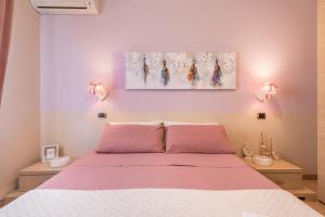 a bedroom with a bed with pink sheets and two lamps at Villa Maria Beatrice in Quartu SantʼElena