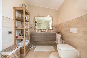 a bathroom with a toilet and a sink and a mirror at Villa Maria Beatrice in Quartu SantʼElena +33 photos