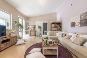 a living room with a couch and a tv at Villa Maria Beatrice in Quartu SantʼElena