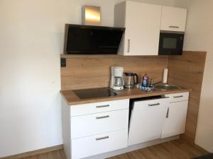 a small kitchen with a sink and a microwave at Villa Bella Vista - Meerblick 1 in Sassnitz