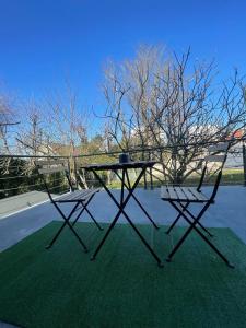a picnic table and two chairs on the grass at La Casa de Lové Suite Jacuzzi in Melun