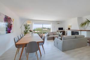 a living room with a table and chairs and a couch at Tres Palmeras in Calas de Mallorca