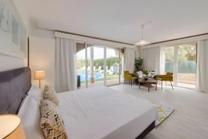 a bedroom with a large bed and a living room at Tres Palmeras in Calas de Mallorca +37 photos