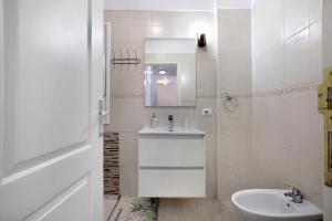a white bathroom with a sink and a mirror at Beach Front Apartment Puertito in Puertito de Güímar +18 photos