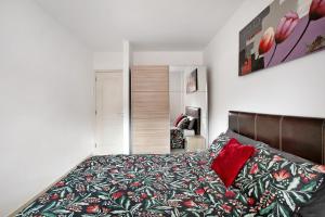 a bedroom with a bed with a red pillow at Beach Front Apartment Puertito in Puertito de Güímar