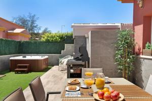 a table with food and drinks on a patio at Villa Hyc Playa de las burras in Maspalomas