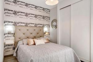 a bedroom with a bed and a wall with writing at Villa Hyc Playa de las burras in Maspalomas +28 photos