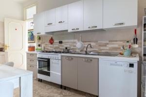 a kitchen with white cabinets and a stove top oven at Casa Ester in Francavilla Fontana