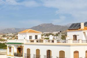 a white house with solar panels on the roof at Terraza Mar y Montaña in Nerja