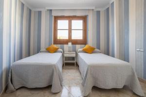 two beds in a room with a window at Terraza Mar y Montaña in Nerja +23 photos