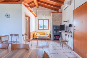 a living room with a yellow couch and chairs at Le colline sul mare in Sortino