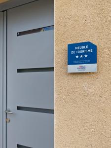 a sign on a wall next to a door at La Maison de violette meublé classé 3 étoiles in Montdidier