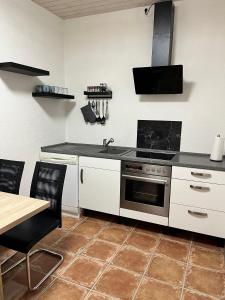 a kitchen with a stove and a table in it at Gemütliche Einliegerwohnung in Imsbach