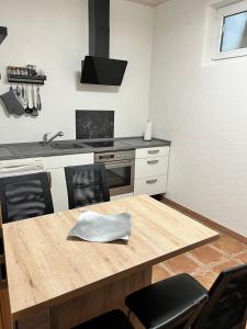 a kitchen with a wooden table and a stove at Gemütliche Einliegerwohnung in Imsbach