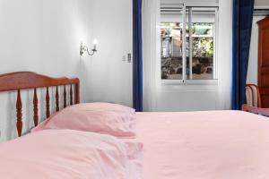 a bedroom with a bed with white sheets and a window at Villa Sauvageonne in Saint-Raphaël