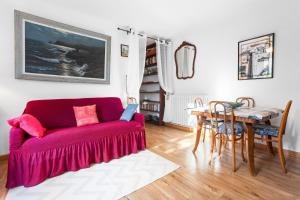 a living room with a red couch and a table at Villa Sauvageonne in Saint-Raphaël