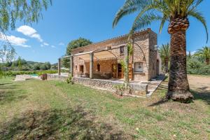 an exterior view of a house with a palm tree at Villa S'erisal in Alaró