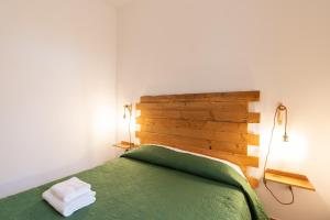 a bedroom with a green bed with two towels on it at Casa delle Pigne in Camporeale